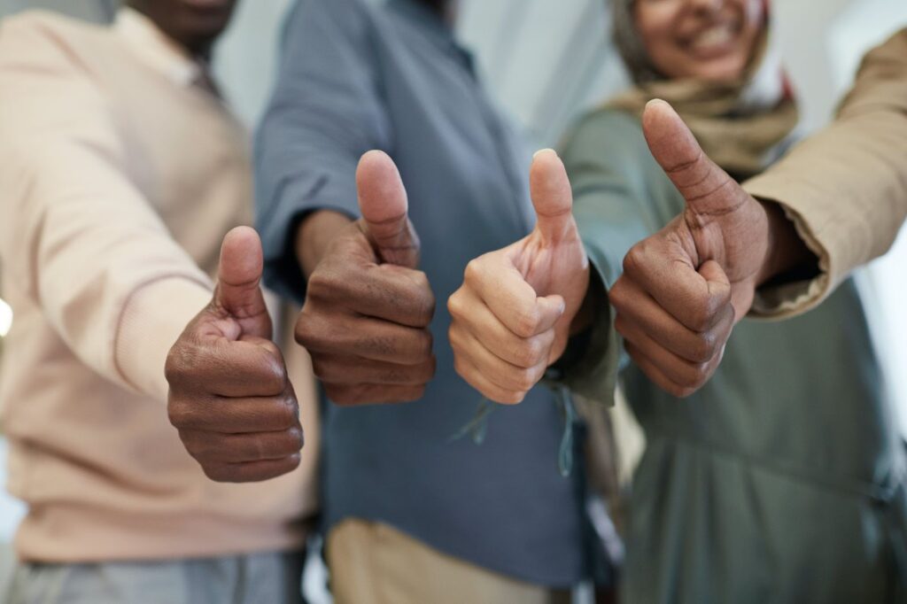 Four People Giving a Thumbs Up