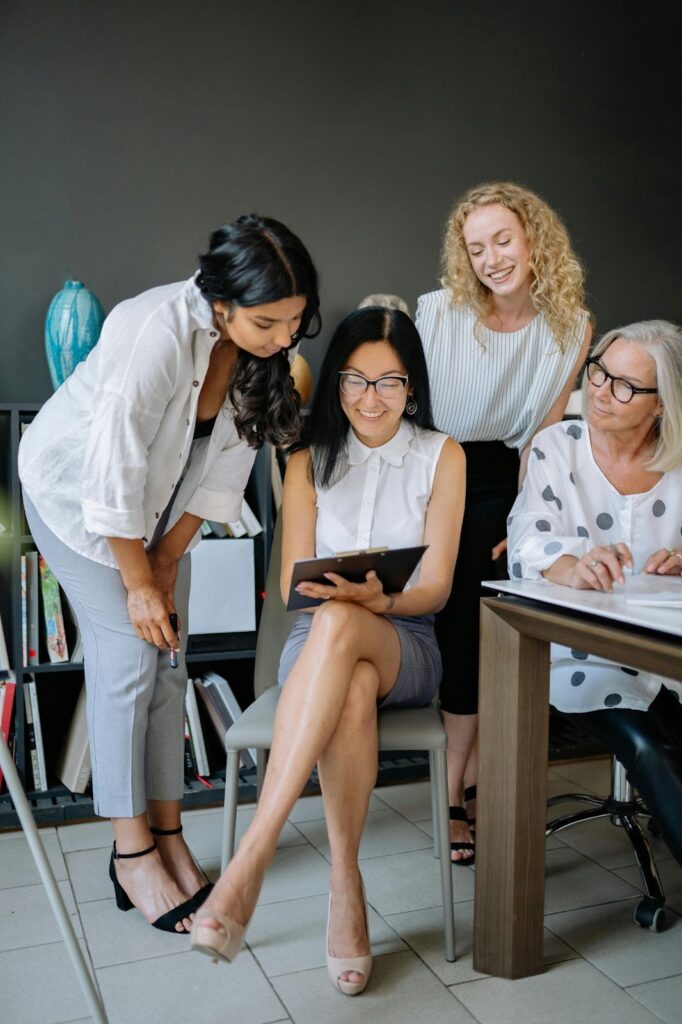 Businesswomen Sitting and Looking at a Clipboard