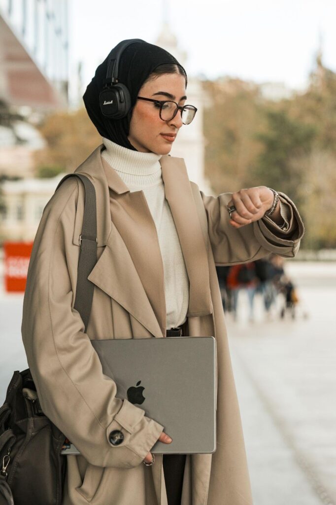 Woman With HeadPhones Holding Laptop and Checking Watch