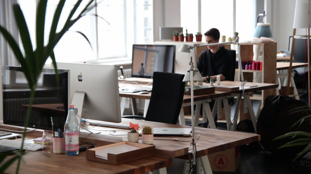 An office environment with plants, tables, and a man working