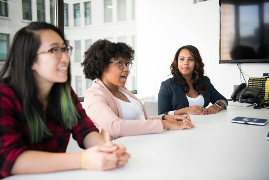 Three Women Talking at Meeting Table