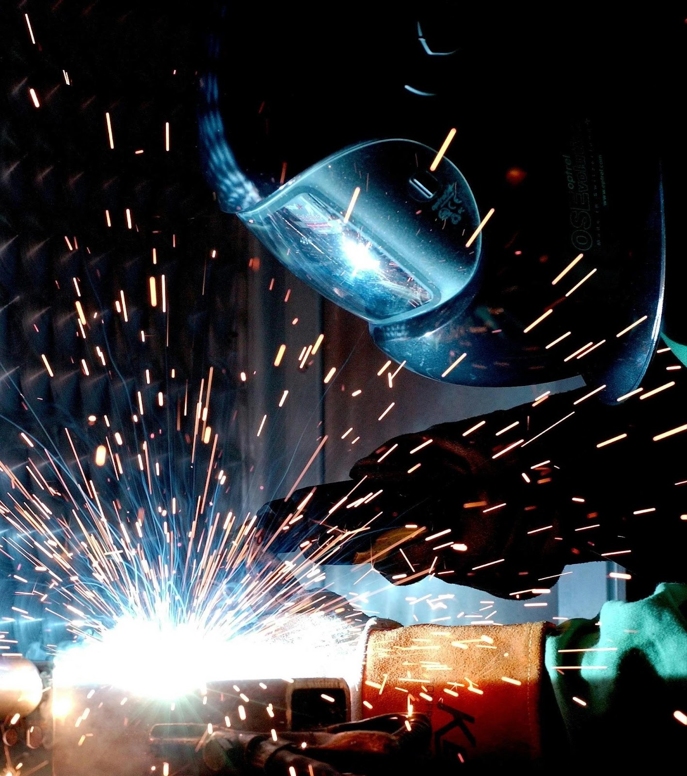 Person in Welding Mask Welding a Metal Bar