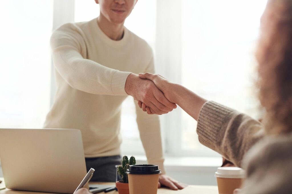 Two People Offering a Handshake in a Business Setting