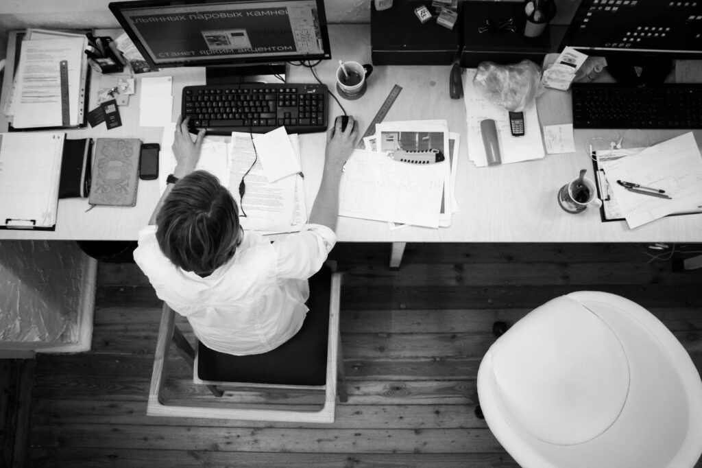 Man Working at Desk with Papers and Computer