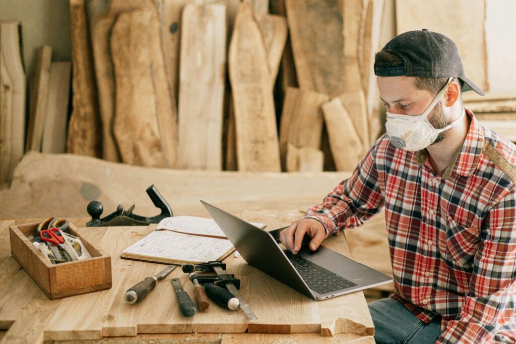 Man on Computer in Woodworking Shop