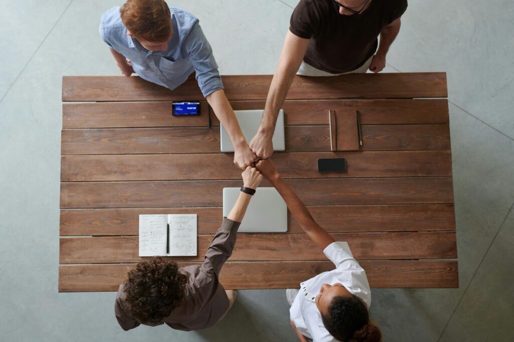 Group of People Fist Bumping Across a Table