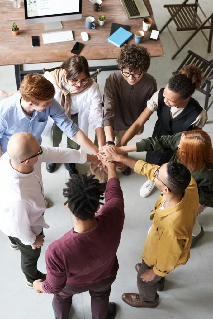 A diverse team of employees celebrating a successful project with high-fives and smiles