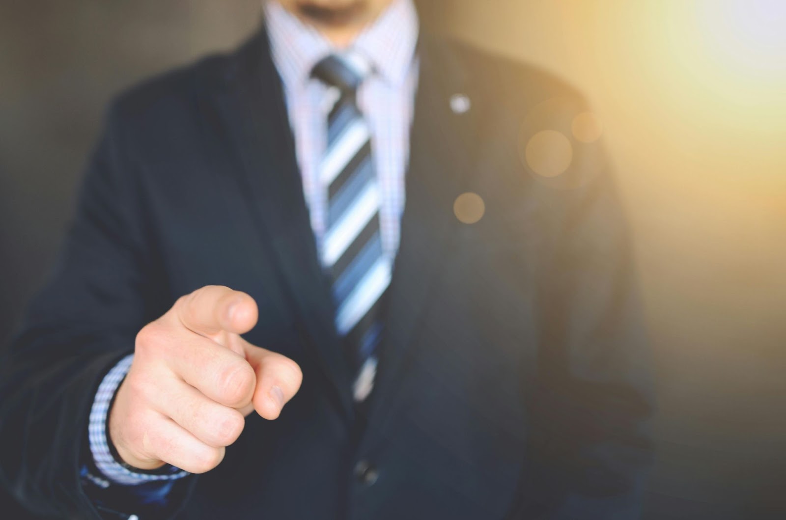 A person in a suit pointing with their finger